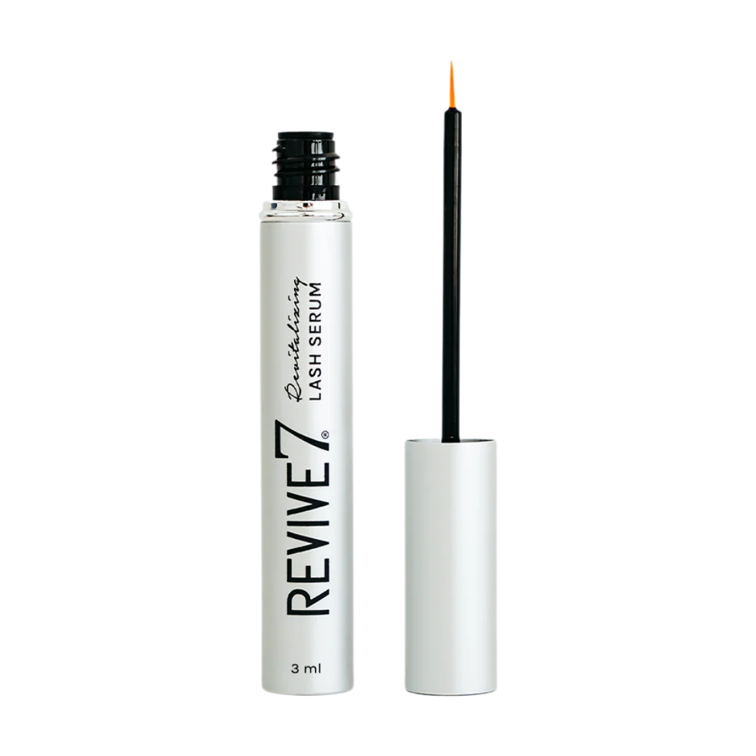 Image du sérum pour cils Revive7 dans son format 3 ml. Le flacon blanc métallique est élégant, avec l’inscription noire « Revive7 Nourishing Lash Serum » à la verticale. Le bouchon est ouvert, laissant apparaître l’applicateur fin muni d’un pinceau à embout orange. Ce sérum canadien est conçu pour stimuler la pousse des cils, les fortifier et les allonger en quelques semaines, sans ingrédients nocifs. Produit recommandé pour un regard naturellement plus dense, idéal en complément d’un rehaussement de cils.