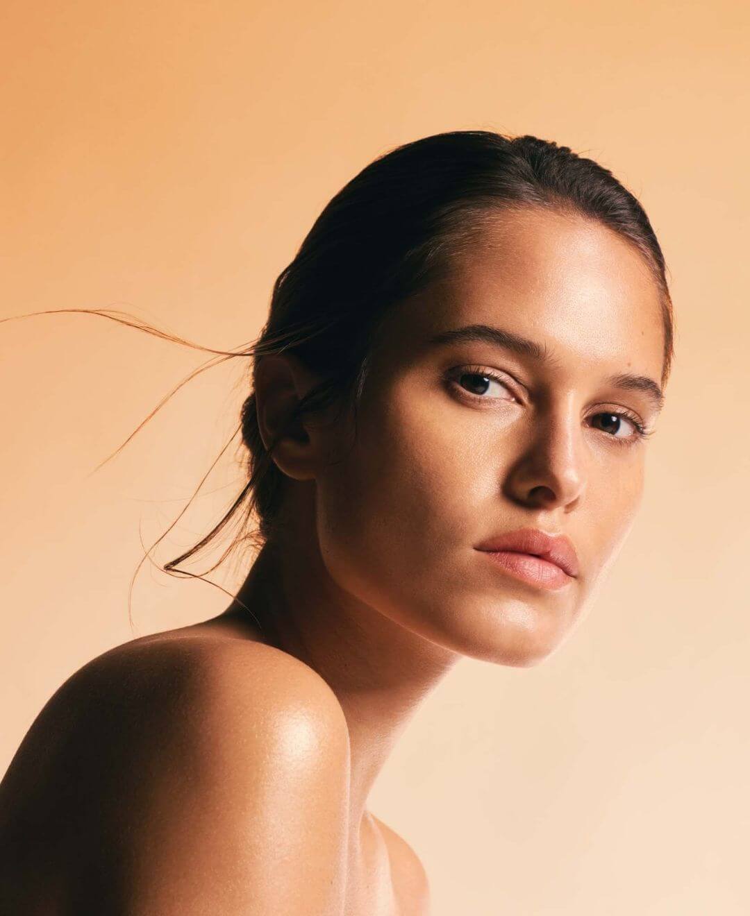 Femme à la peau lumineuse avec bronzage naturel sublimé grâce à l’Huile Sèche 3 Soleils Esthederm FPS 30 – Concept Beauté Québec