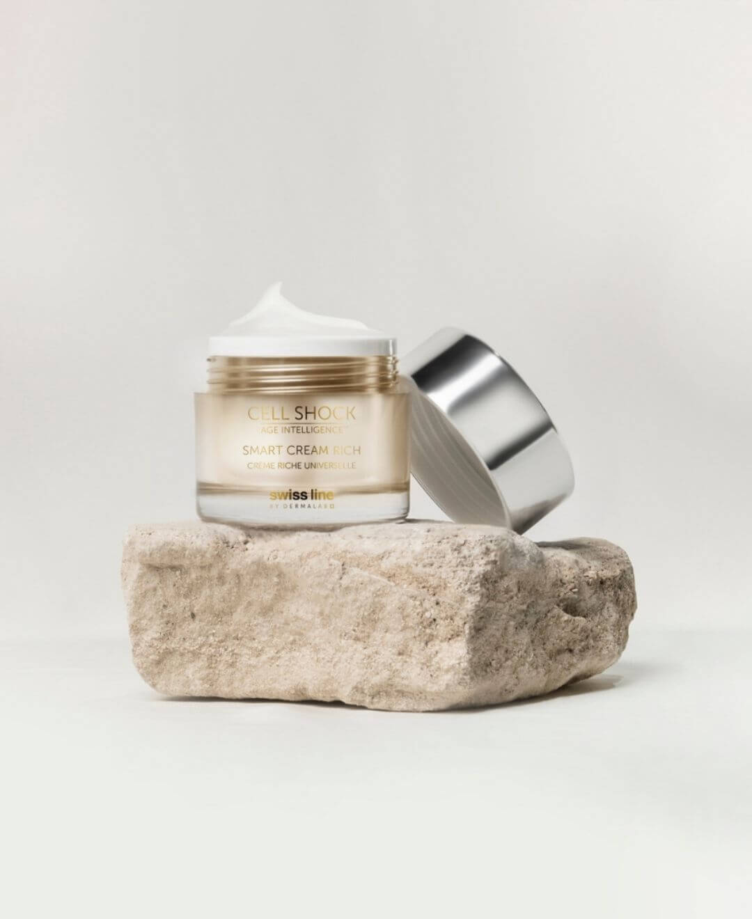 Smart Cream Rich Cell Shock de Swissline, crème riche anti-âge présentée ouverte sur une pierre au style épuré.