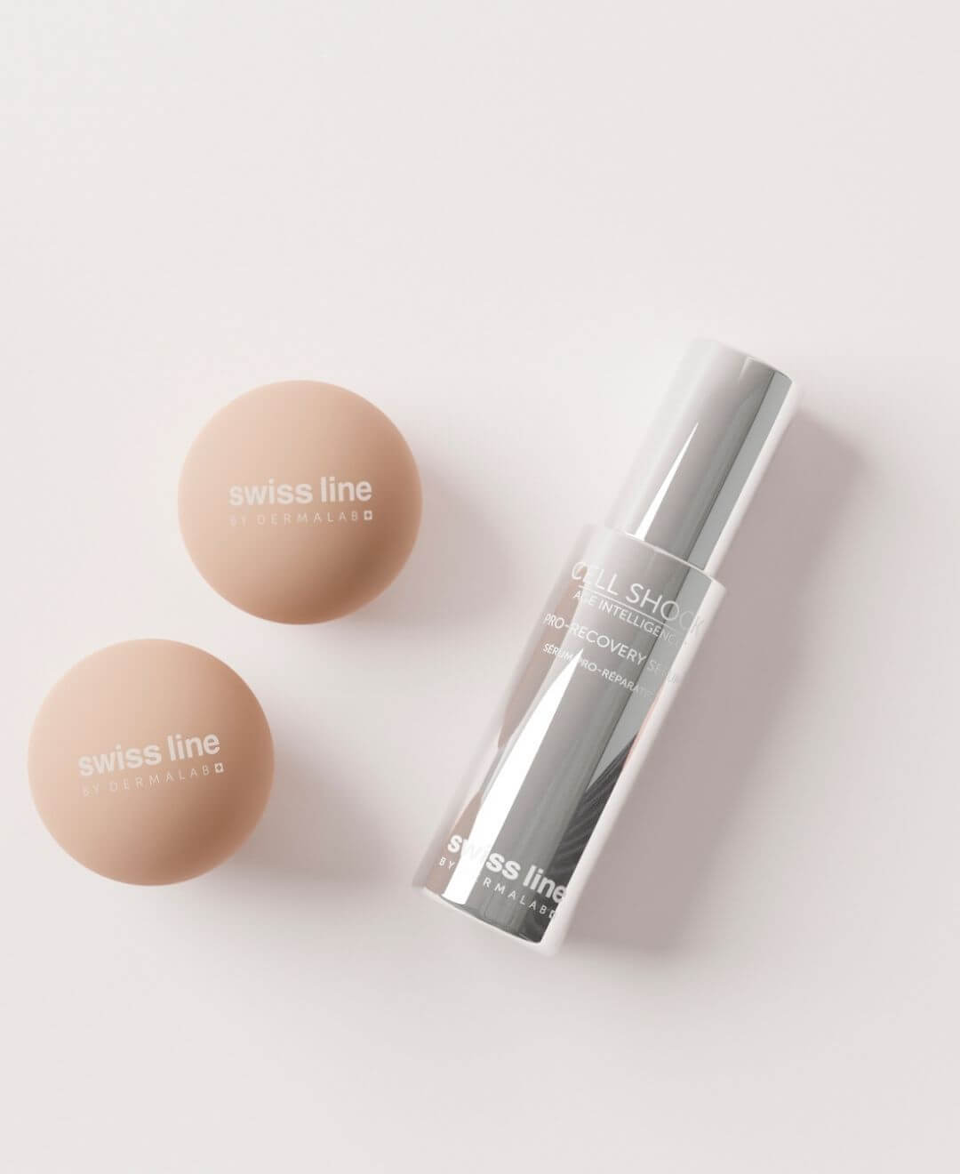 Sérum Pro-Recovery Cell Shock Swissline avec éponges de maquillage sur fond clair, univers soin visage réparateur.