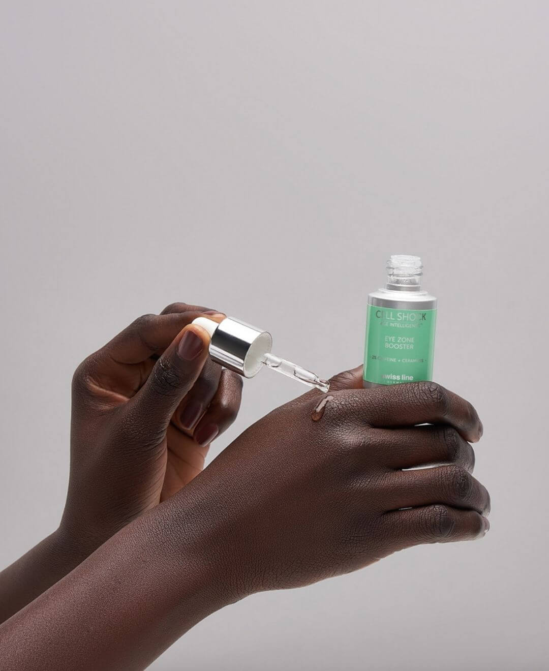 Application du soin contour des yeux Eye Zone Booster Cell Shock Swissline avec pipette, texture fluide sur la peau.