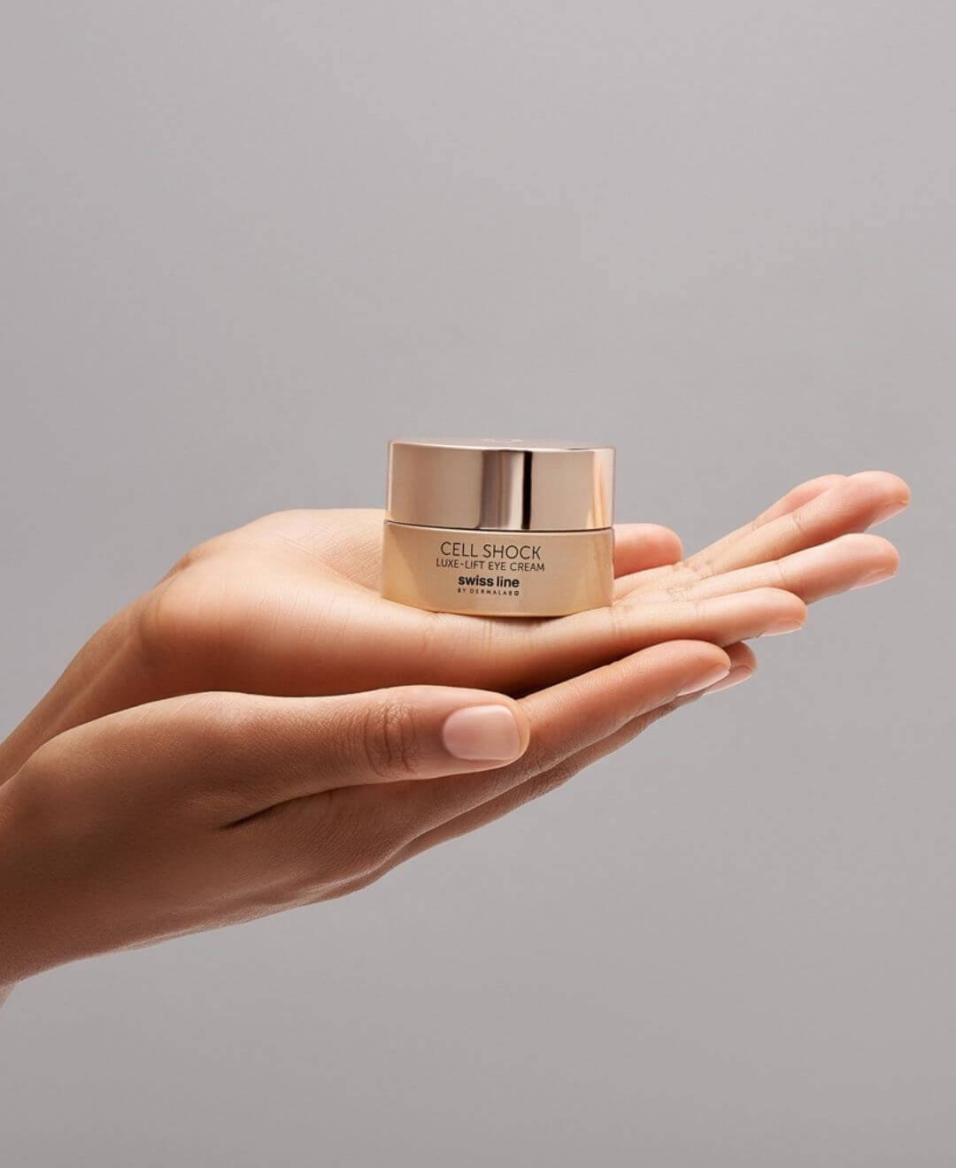 Crème contour des yeux Luxe-Lift Cell Shock Swissline déposée dans la main, soin anti-âge raffermissant pour le regard.