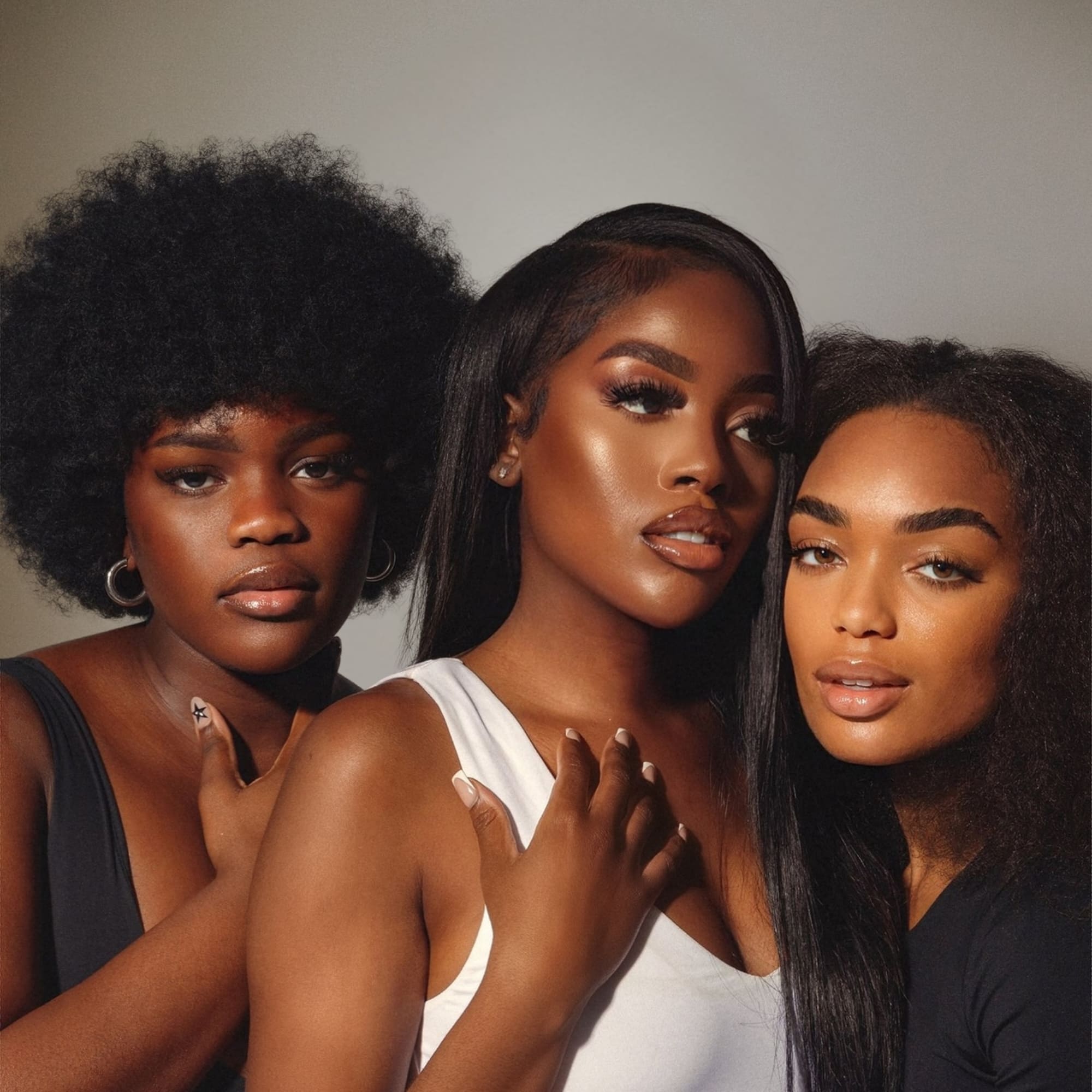 Trois femmes aux peaux foncées illustrant la diversité des phototypes IV à VI et le peeling épidermique MeLine pour peaux ethniques. Soin offert chez Concept Beauté Cap-Rouge, Charlesbourg et Lac-Beauport.