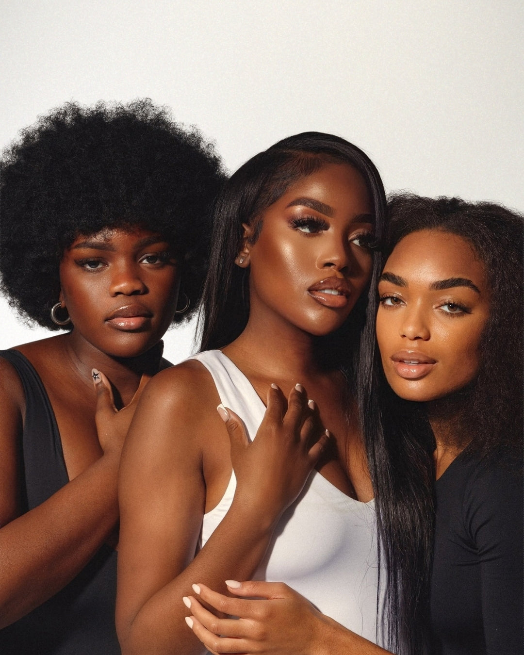 Trois femmes à la peau lumineuse illustrant le Peeling Dermique pour peaux ethniques chez Concept Beauté, soin rénovateur éclat et uniformité.